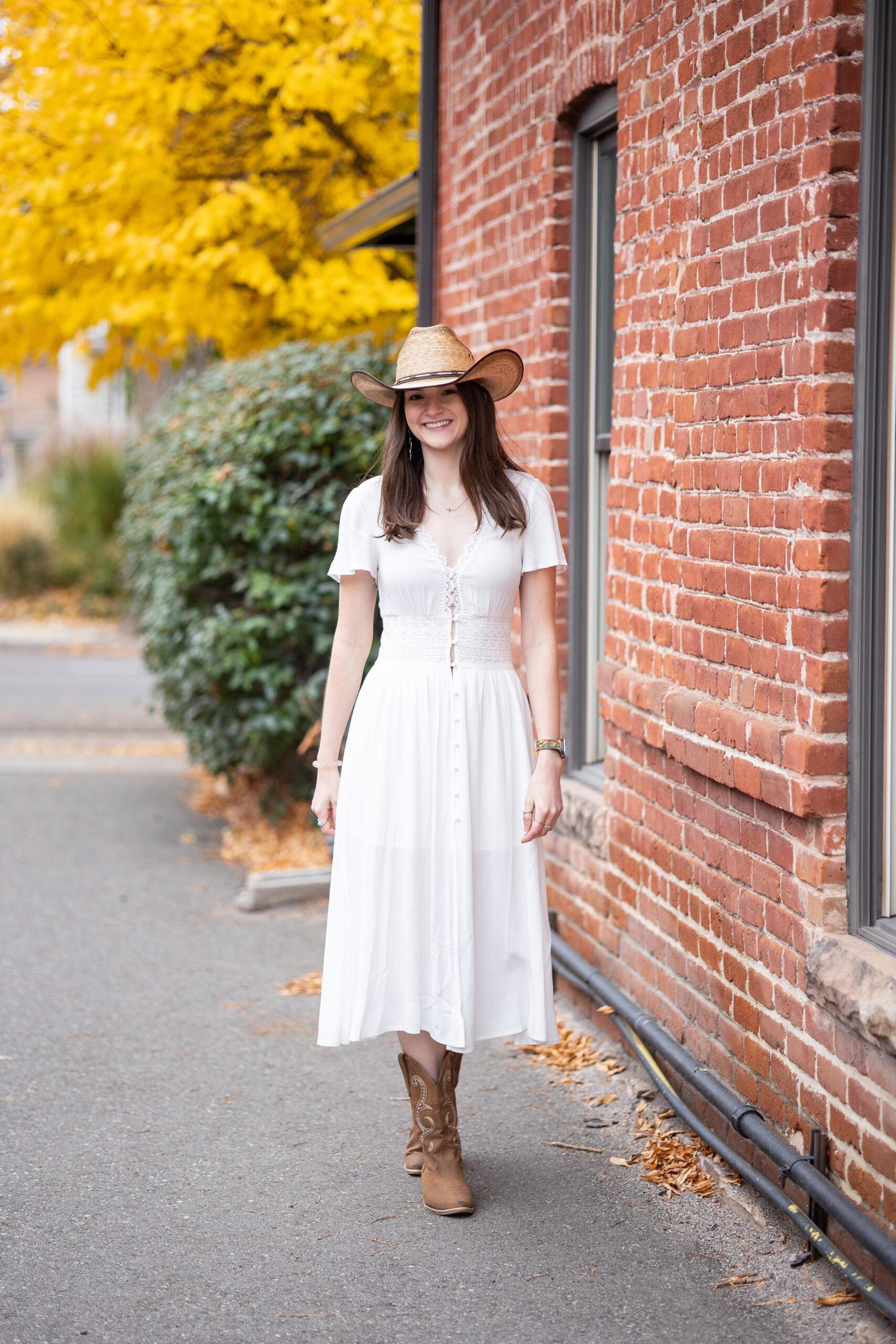 Senior girl wearing a cowboy hat for fall photo session in downtown Littleton